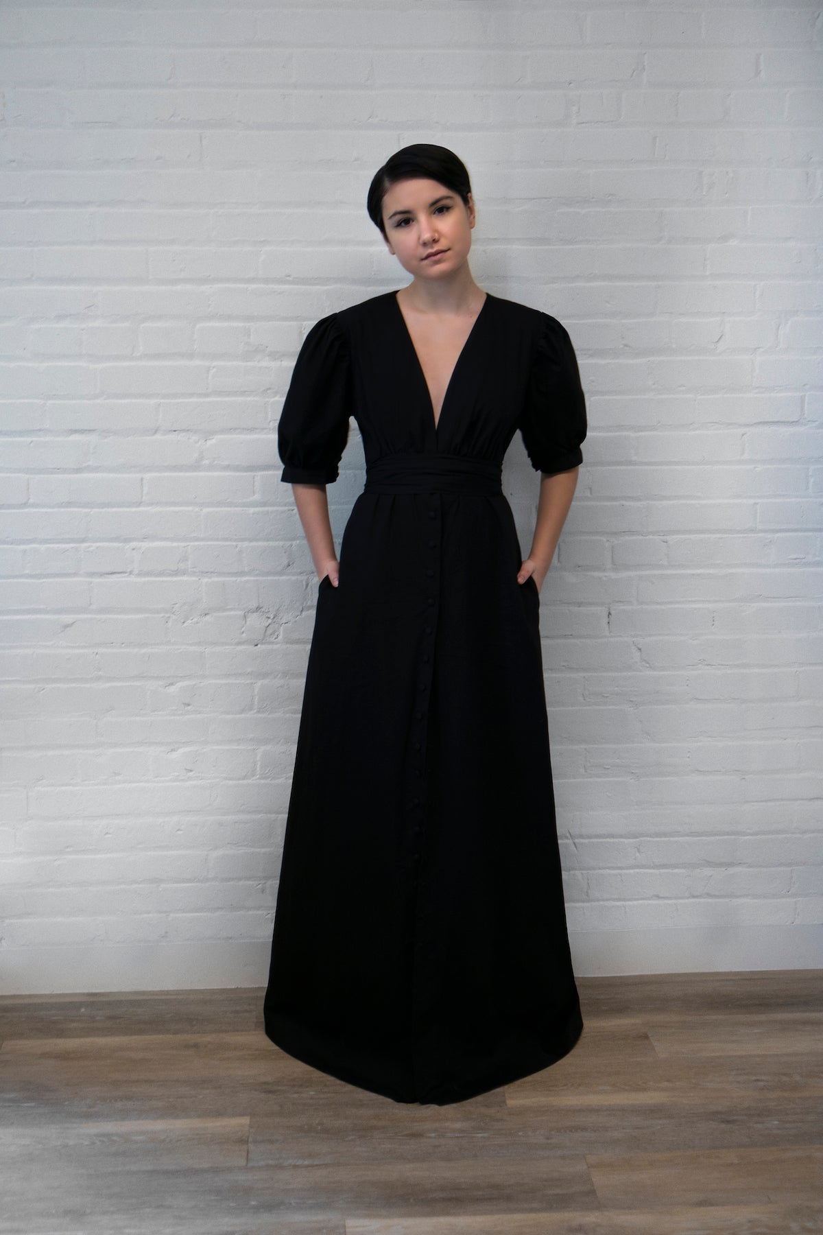 a low v-neck black maxi dress with puff sleeves and snap front closure and pockets